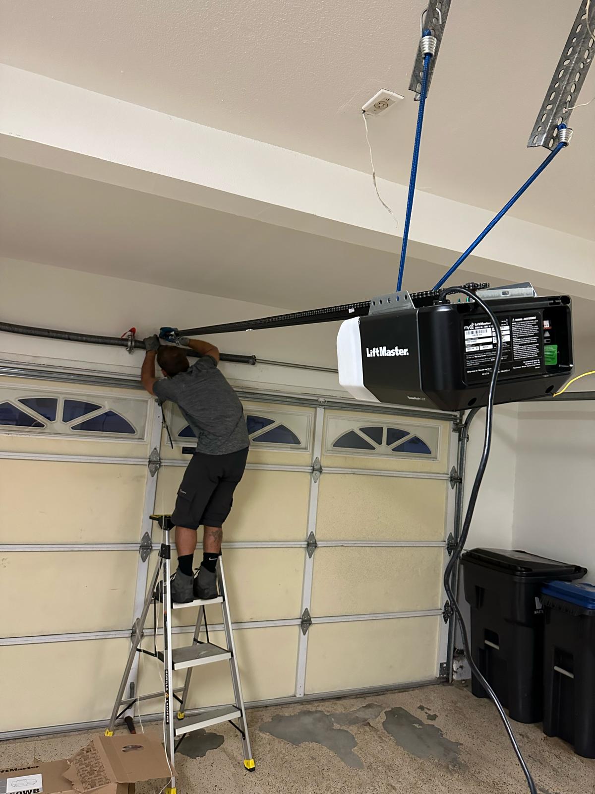 Dean's Garage Door technician servicing a garage door opener in Long Beach