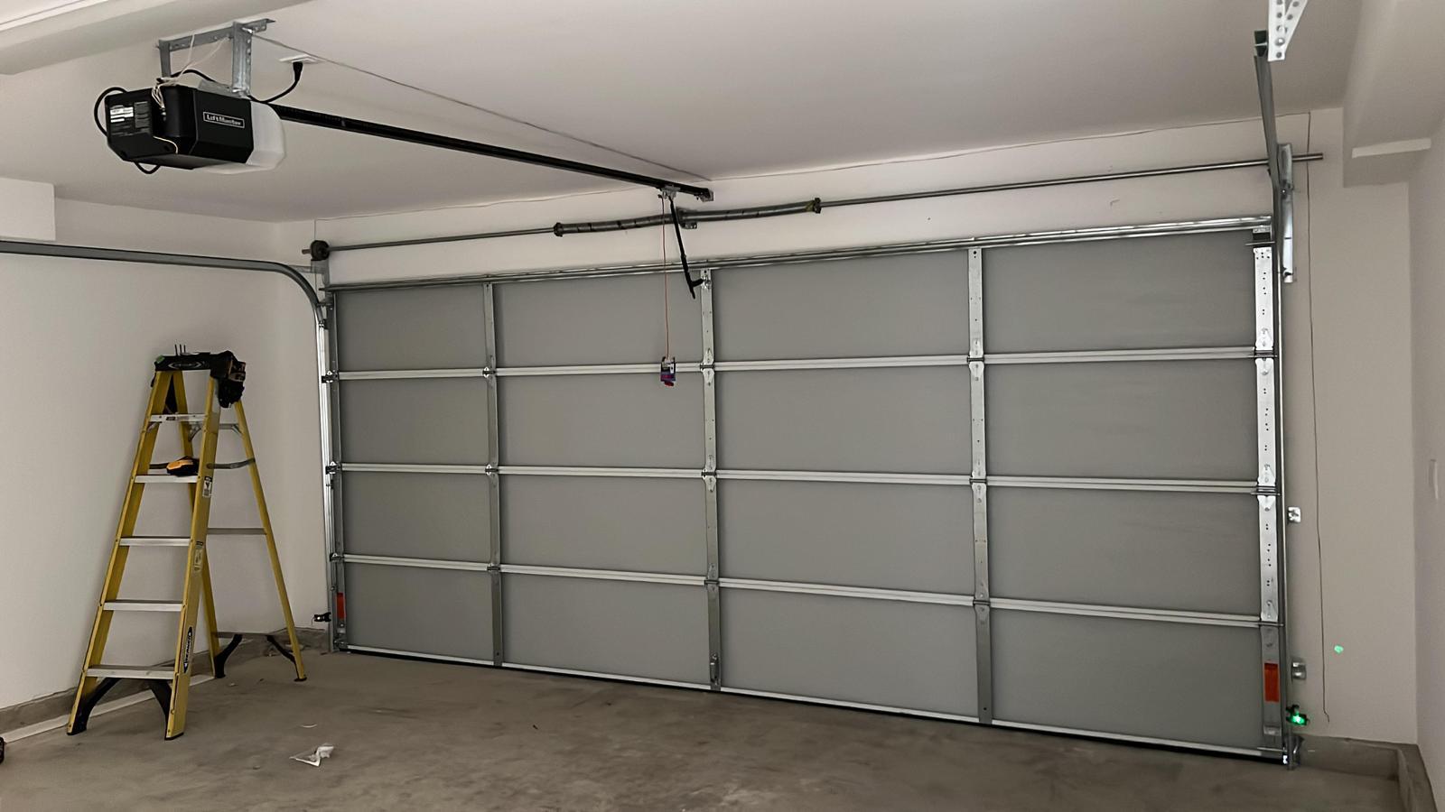 Interior garage showing LiftMaster opener and torsion spring assembly — key components for garage door lubrication